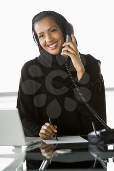 Royalty Free Photo of a Woman at a Desk on a Telephone