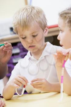 Royalty Free Photo of a Child With Beads in a Classroom