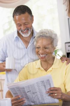 Royalty Free Photo of a Couple Reading a Newspaper