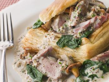 Royalty Free Photo of Chicken Livers Spinach and Girolle Mushrooms Served in a Vol-au-Vent Case With Grain Mustard Sauce