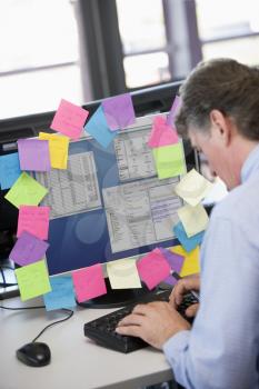 Royalty Free Photo of a Man With Notes on His Computer