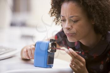 Royalty Free Photo of a Woman Using a Pencil Sharpener