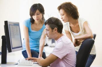 Royalty Free Photo of Three People Looking at a Computer