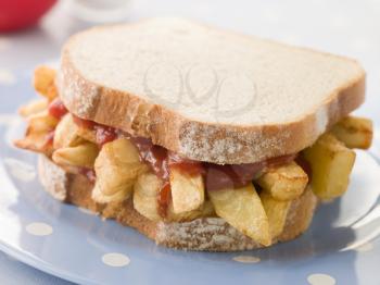 Royalty Free Photo of a Chip Sandwich on White Bread With Tomato Ketchup