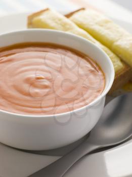 Royalty Free Photo of a Bowl of Tomato Soup With Cheesy Toasted Soldiers
