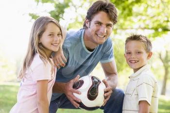 Royalty Free Photo of a Man and Two Children With a Ball