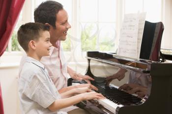 Royalty Free Photo of a Man Teaching a Boy Piano