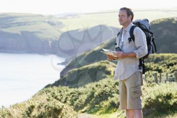 Royalty Free Photo of a Man on a Cliff With a Map