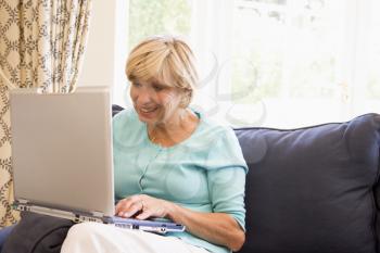 Royalty Free Photo of a Woman in a Living Room With a Laptop