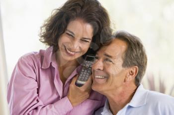 Royalty Free Photo of a Couple Listening in on a Phone Together