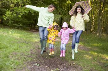 Royalty Free Photo of a Family Skipping in the Rain