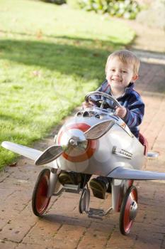 Royalty Free Photo of a Little Boy in a Toy Airplane