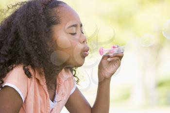 Royalty Free Photo of a Young Girl Blowing Bubbles