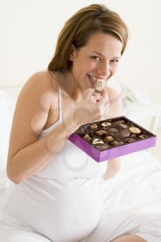 Royalty Free Photo of a Pregnant Woman Eating Chocolate