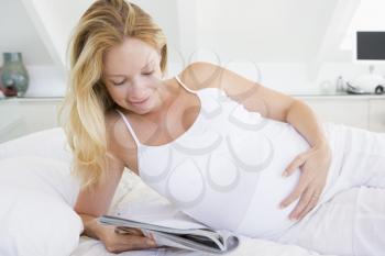 Royalty Free Photo of a Pregnant Woman Reading a Magazine