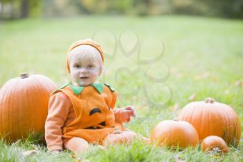 Royalty Free Photo of a Baby in a Pumpkin Costume With Pumpkins