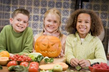 Royalty Free Photo of Three Children With a Jack-o-Lantern