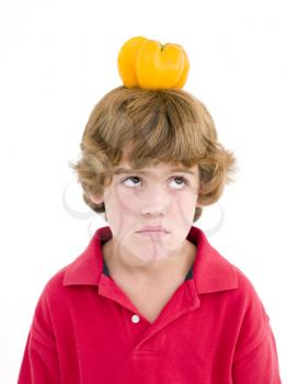 Royalty Free Photo of a Boy With a Yellow Pepper on His Head