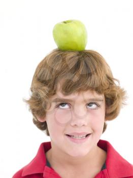 Royalty Free Photo of a Boy With an Apple on His Head