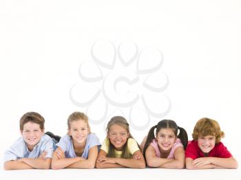 Row of five friends lying down smiling