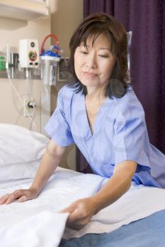 Royalty Free Photo of a Nurse Making a Hospital Bed