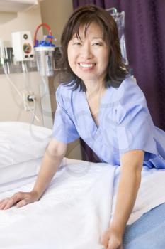 Royalty Free Photo of a Nurse Making a Hospital Bed