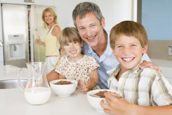 Royalty Free Photo of a Father Having Breakfast With His Children and His Wife in the Background