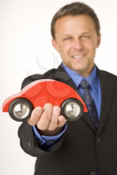 Royalty Free Photo of a Businessman Holding a Toy Car
