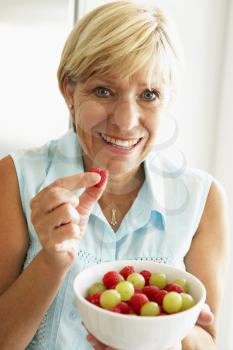 Royalty Free Photo of a Woman Eating Fruit