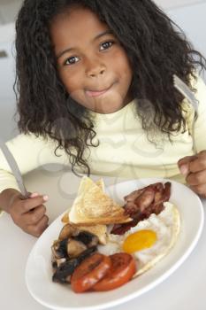 Royalty Free Photo of a Little Girl Eating Bacon and Eggs