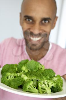 Royalty Free Photo of a Guy With a Plate of Broccoli