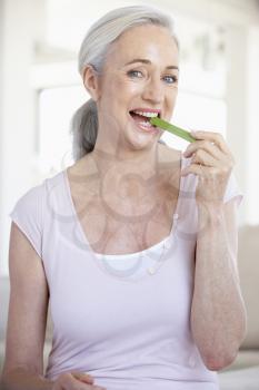 Royalty Free Photo of a Woman Eating Celery