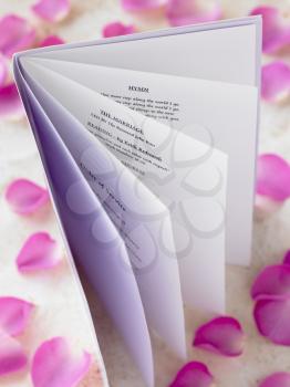 Royalty Free Photo of a Wedding Booklet Surrounded by Rose Petals
