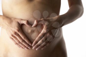 Royalty Free Photo of a Pregnant Woman Forming a Heart Over Her Belly