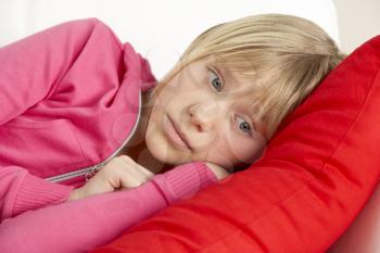 Royalty Free Photo of a Young Girl Looking Sad Lying on a Pillow