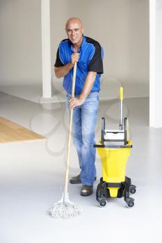 Royalty Free Photo of a Man Mopping a Floor
