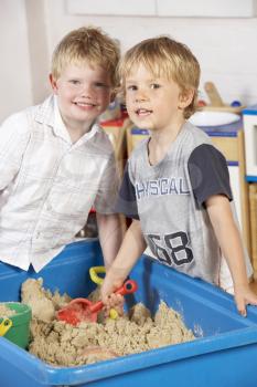 Royalty Free Photo of Two Boys Playing in a Sandbox