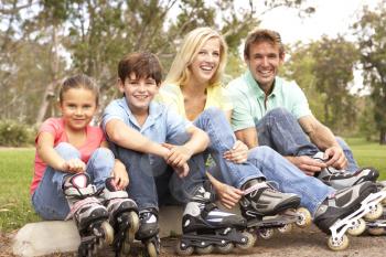 Royalty Free Photo of a Family Putting on Roller Blades