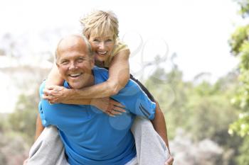 Royalty Free Photo of a Man Giving a Woman a Piggyback Ride