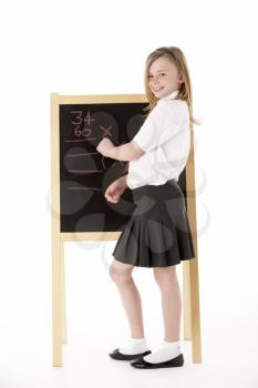 Thoughtful Female Student Wearing Uniform Next To Blackboard