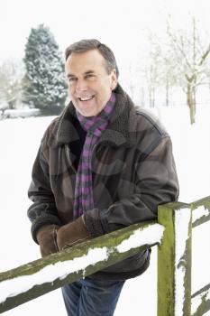 Senior Man Standing Outside In Snowy Landscape