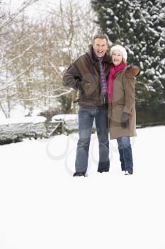 Senior Couple Walking In Snowy Landscape