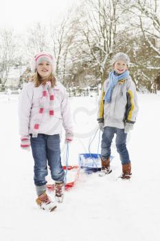 Children Pulling Sledge Through Snowy Landscape