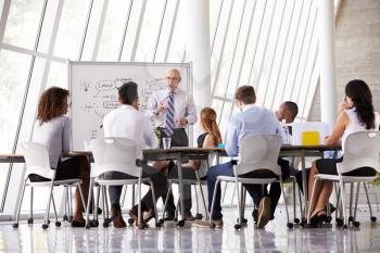 Senior Businessman Leading Meeting At Boardroom Table