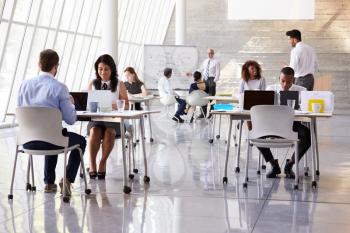 Businesspeople Working At Desks In Modern Office