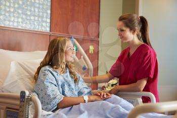 Nurse Talking To Female Teenage Patient In Hospital