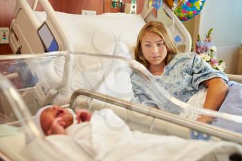 Worried Teenage Girl With Crying Newborn Baby In Hospital