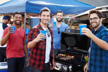 Group Of Male Sports Fans Tailgating In Stadium Car Park