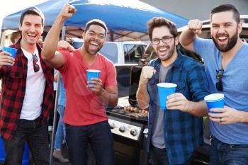 Group Of Male Sports Fans Tailgating In Stadium Car Park