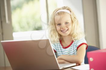 Young Girl Using Laptop At Home